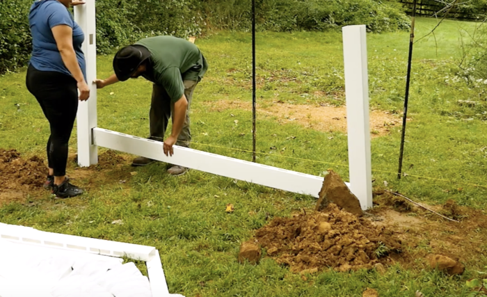 Step 3 of vinyl fence installation inserting bottom rail