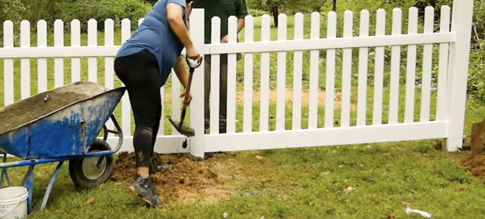 Step 5 of vinyl fence installation covering footing with dirt